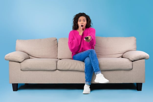 A person sitting on a couch, looking surprised or concerned while holding a remote control, with a TV screen showing the Disney+ interface in the background.