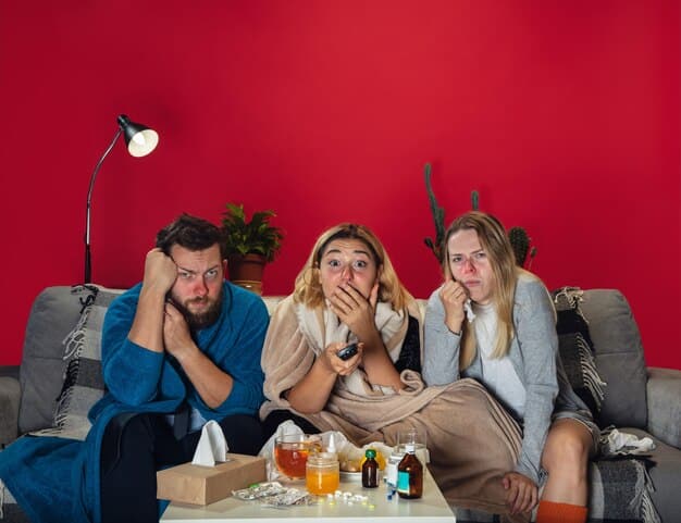 A group of friends gathered on a couch, engrossed in watching a suspenseful scene on a large television screen. The room is dimly lit, with a bowl of popcorn on the table, emphasizing the cozy and immersive experience of streaming at home. The faces of the viewers reflect a mix of excitement and anticipation, capturing the thrill of watching new content together.