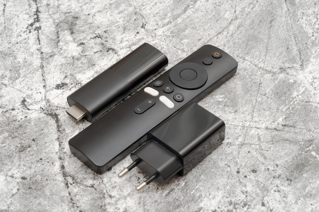 A close-up shot of various streaming devices (Roku, Amazon Fire Stick, Apple TV) connected to a TV.