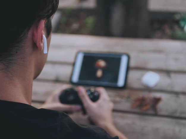 A person wearing headphones and using a smartphone with a streaming app open. The screen shows audio description settings with options to adjust the volume and narration speed, highlighting the customization available for visually impaired users.