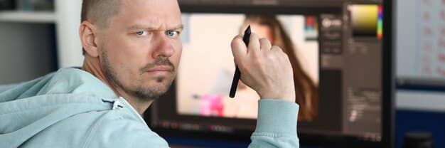 A close-up shot of a director looking intently at a monitor on a film set. He is wearing a headset and has a serious, focused expression. In the background, there are crew members and equipment, suggesting a busy and collaborative environment.