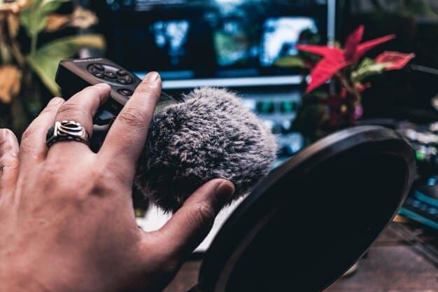A close-up shot of a Foley artist's hands manipulating various props in a sound studio, replicating sounds such as footsteps on gravel or the rustling of clothing. The setting is dimly lit with a focused spotlight on the artist's workspace.