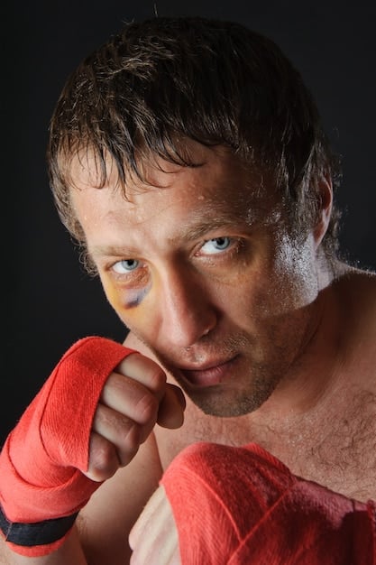 A close-up shot of Jeremy Strong as Kendall Roy, showcasing a mix of exhaustion and determination in his eyes. He is holding a tumbler of some kind. The lighting enhances the shadows on his face, emphasizing the burden he carries as he navigates the challenges of leading Waystar RoyCo.