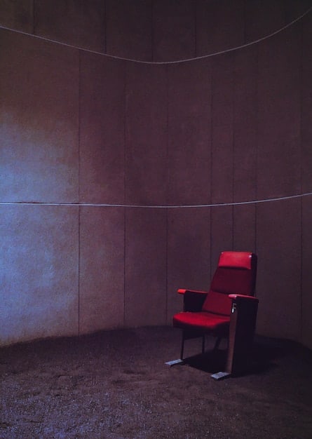 A darkened, nearly empty independent movie theater, symbolizing the struggles faced by smaller venues and studios due to pandemic-related disruptions.
