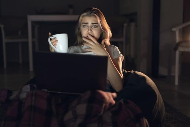 A woman sitting on her couch at night, illuminated by the glow of her laptop screen as she watches a horror movie. She is holding a blanket close, with a look of fear and anticipation on her face.