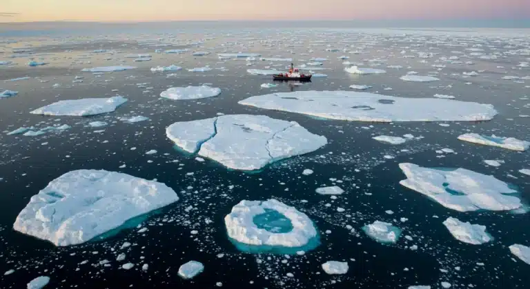 Rapidly melting Arctic icecap with open water, signifying climate crisis urgency.