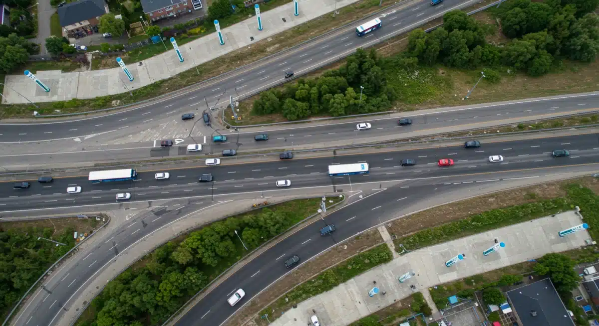 Aerial view of electric vehicles on a highway with integrated charging stations