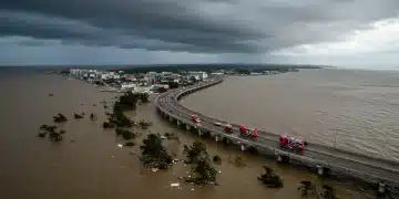 Coastal city experiencing severe flooding from extreme weather, with emergency response in progress.